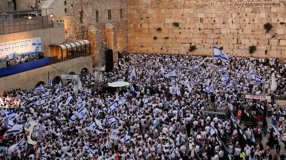 Demonstrators gather with Israeli flags at the Western Wall in the old city of Jerusalem on May 29, 2022, during the Israeli 'flags march' to mark "Jerusalem Day".  - Thousands of flag-waving Israelis marched on May 29 into the Muslim quarter of Jerusalem's Old City during a nationalist procession that regularly stokes Palestinian anger, a year after Jerusalem tensions exploded into war.  (Photo by GIL COHEN-MAGEN  /  AFP)