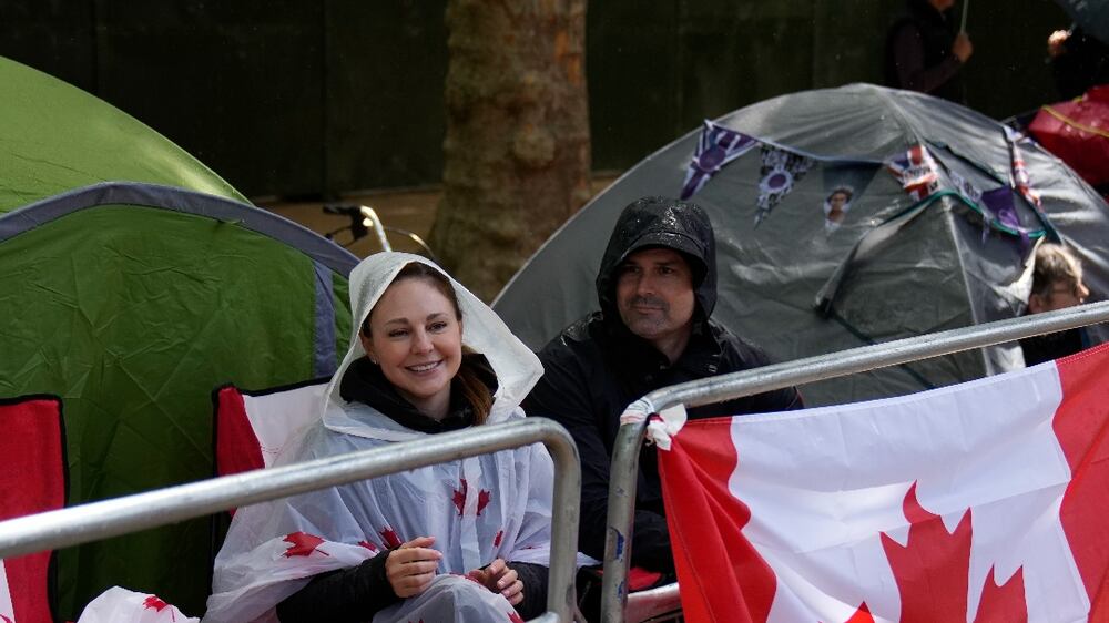 International royal fans Angie Hart, left, and Pat, second left, from Brantford, in Ontario, Canada sit by the front of the crowd barriers on The Mall waiting for the start of Britain's Queen Elizabeth II's Platinum Jubilee, in London, Tuesday, May 31, 2022.  Celebrations will take place June 2-5 to mark Queen Elizabeth II's Platinum Jubilee, for her 70 years on the throne.  (AP Photo / Matt Dunham)