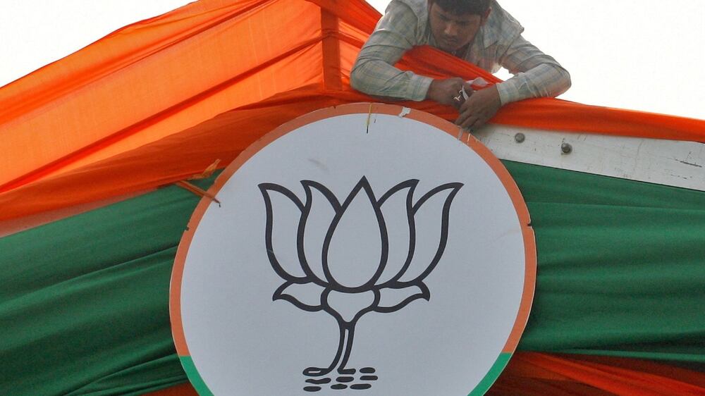 FILE PHOTO: A man installs the symbol of India's ruling Bharatiya Janata Party (BJP) on a tent during an election campaign rally by the party in Prayagraj, India, February 24, 2022.  REUTERS / Ritesh Shukla / File Photo