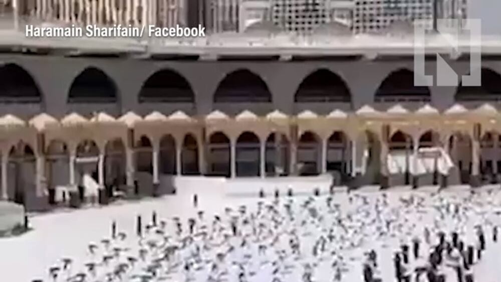 Pilgrims maintain distance as they circle around Kaaba during Hajj