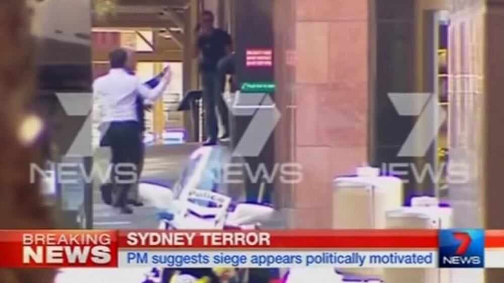 Hostages run from under-siege Sydney cafe