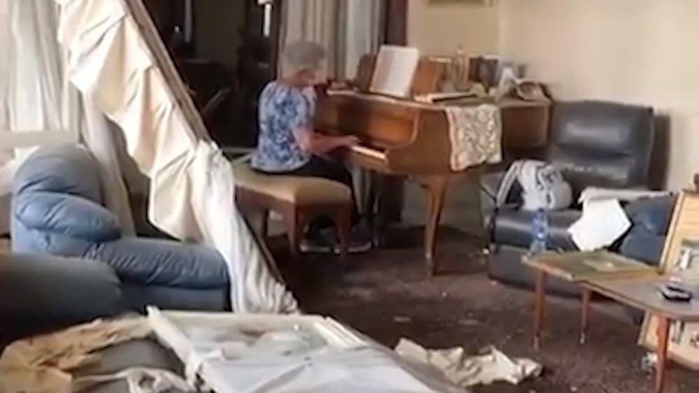 Grandmother plays piano amid rubble