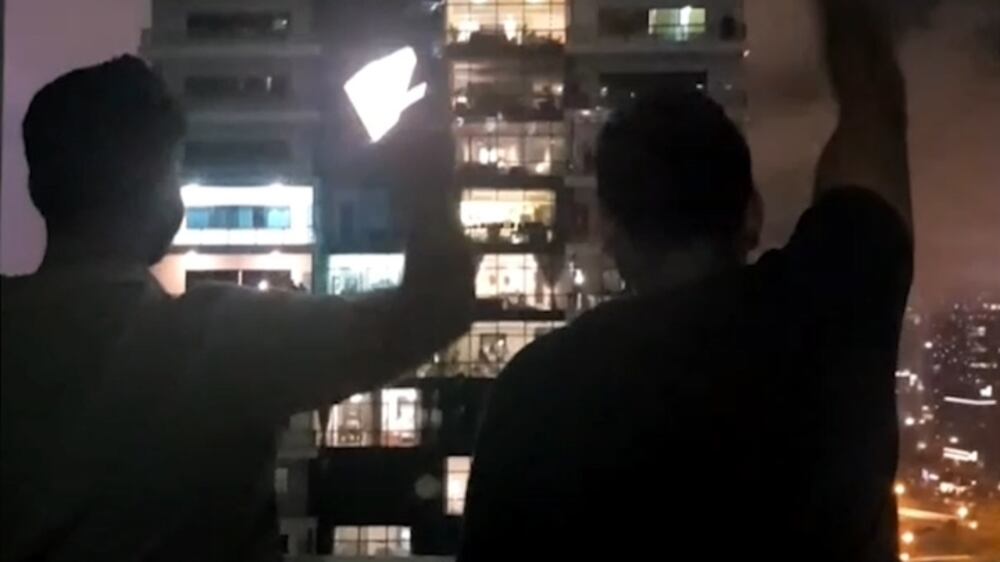 People cheer from balconies during Dubai storm