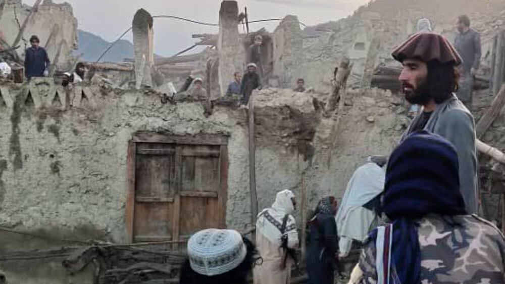 In this photo released by a set-run news agency Bakhtar, Afghans look at destruction caused by an earthquake in the province of Paktika, eastern Afghanistan, Wednesday, June 22, 2022.  (Bakhtar News Agency via AP)