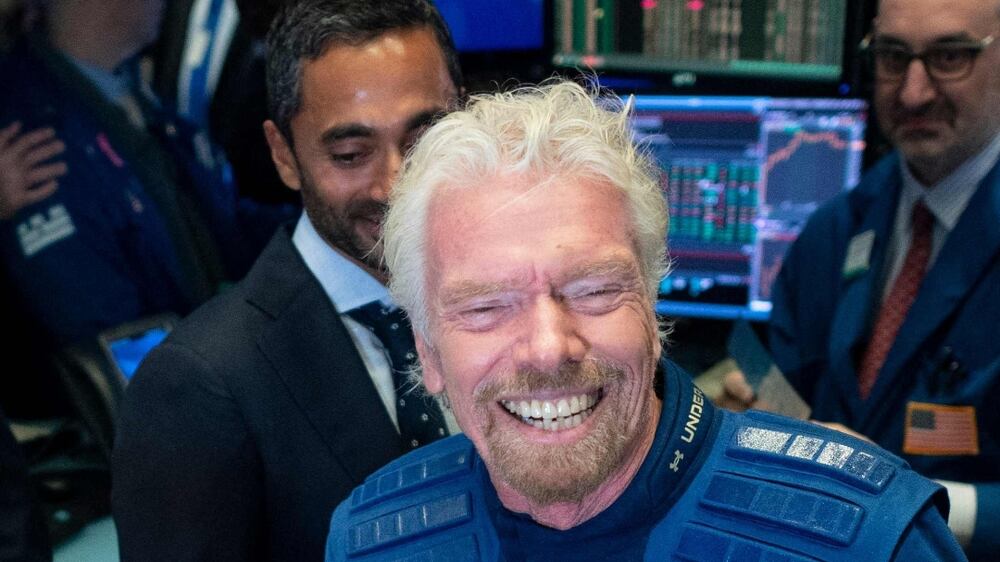 (FILES) In this file photo taken on October 28, 2019 Richard Branson, Founder of Virgin Galactic (C) poses next to George T.  Whitesides (R), CEO of Virgin Galactic Holdings after ringing the First Trade Bell to commemorate the company's first day of trading on the New York Stock Exchange (NYSE) in New York City.  - He's always dreamed of it, and in 2004 founded his own company to make it happen.  On July 11, 2021, billionaire Richard Branson will take off from a base in New Mexico aboard a Virgin Galactic vessel bound for the edge of space.  The Briton is hoping to finally get the nascent space tourism industry off the ground -- but also go one up on Jeff Bezos by winning the race to be the first person to cross the final frontier in a ship built by their own company.  (Photo by Johannes EISELE  /  AFP)