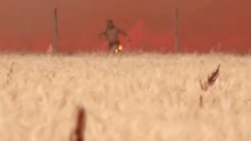 A man emerges from flames with burning clothes, as a wildfire burns in Tabara, Zamora Province, Spain, July 18, 2022 in this screen grab taken from a video.  REUTERS / Guillermo Martinez