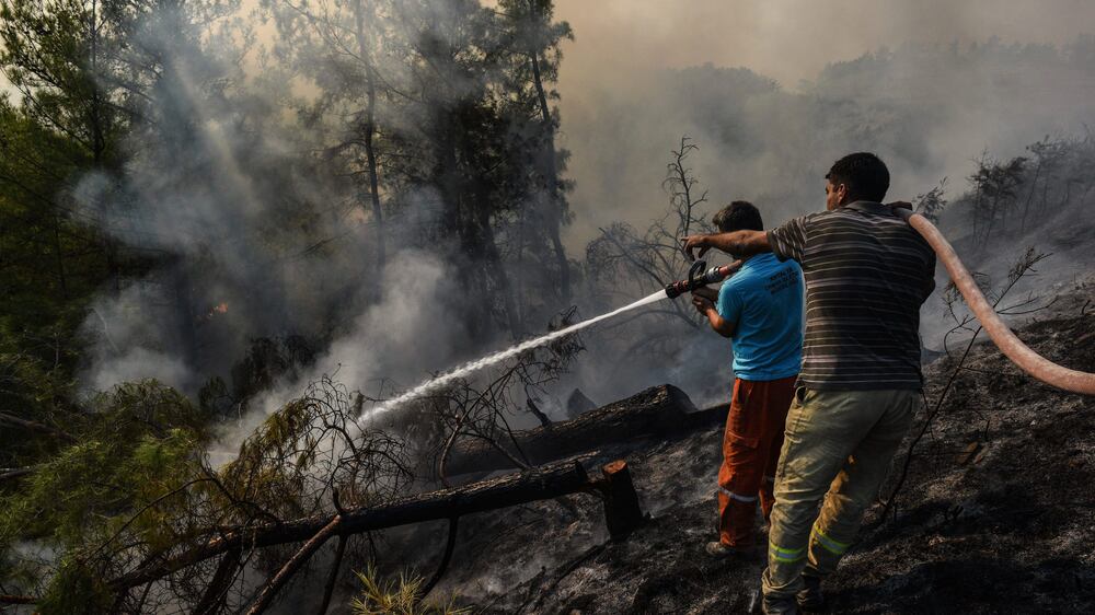 Villagers water trees to stop the wildfires that continue to rage the forests in Manavgat, Antalya, Turkey, early Sunday, Aug.  1, 2021.  The fires in Antalya were continuing overnight in Manavgat and Gundogmus districts.  In Bodrum, Mugla, they continued to burn down forests, encroaching on villages and tourist destinations and forcing people to evacuate by boats.  (AP Photo)