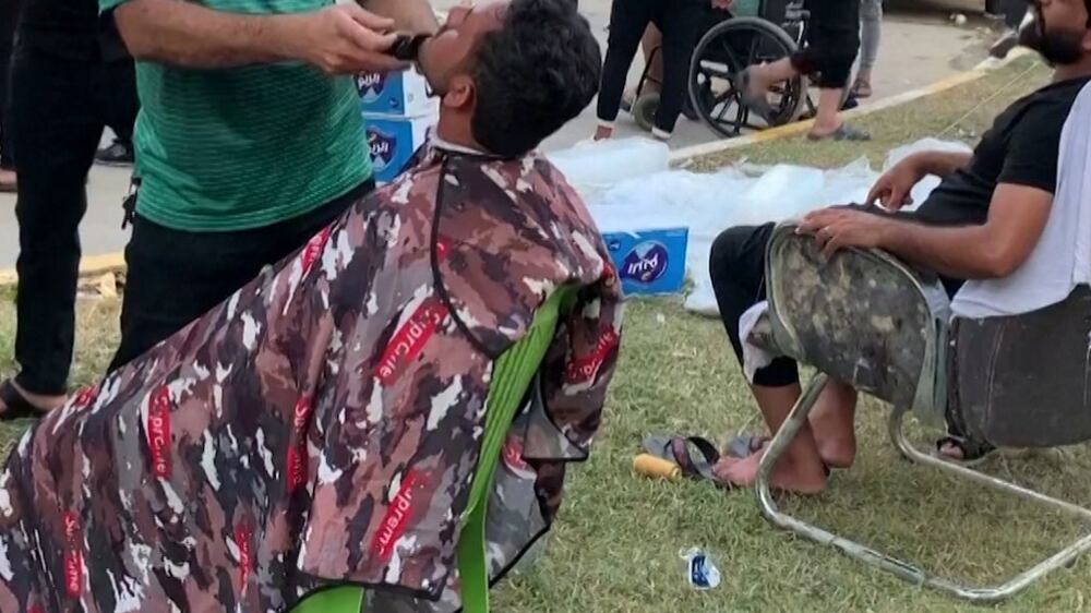 Free haircuts outside Iraq's Parliament where hundreds continue their sit-in
