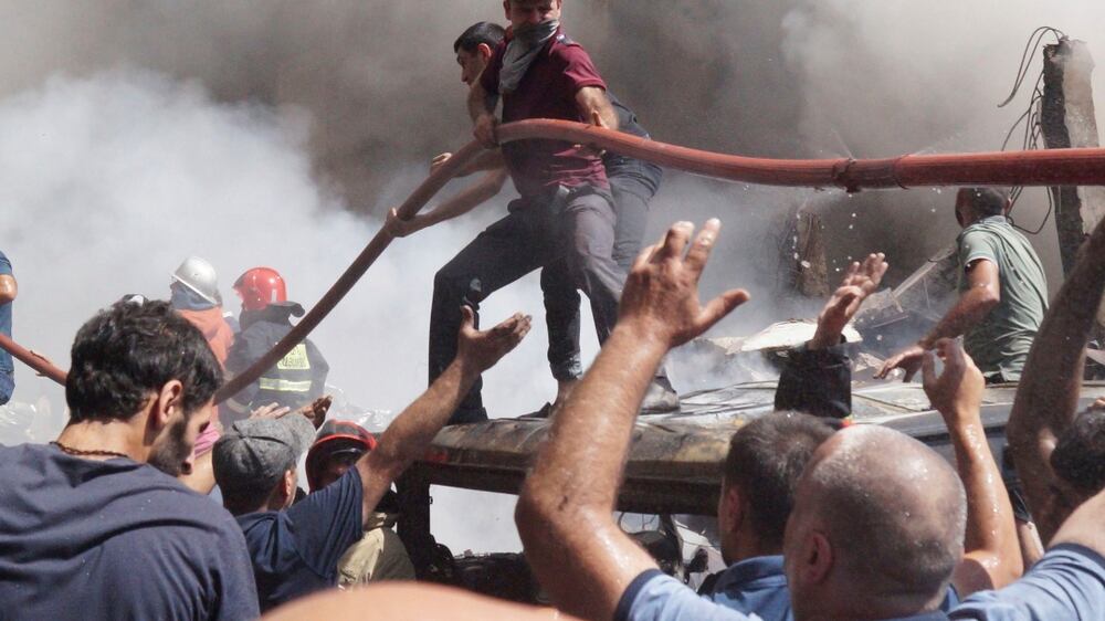 People help firefighters to deliver water to extinguish flames at Surmalu market about two kilometers (1. 2 miles) south of the center Yerevan, Armenia, Sunday, Aug.  14, 2022.  A strong explosion at a fireworks storage area has ripped through a market in Armenia's capital.  At least one person has been killed and about 20 others have been injured.  The blast on Sunday set off a large fire.  (AP Photo / Daniel Bolshakov)