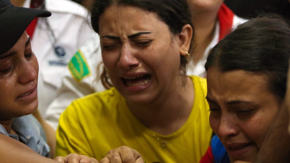 People react during the funeral for victims who died in the Abu Sifine church fire, inside the Church of the Blessed Virgin Mary, in the Warraq Al Arab district, 14 August 2022.  According to the ministry of health, at least 41 people were killed and dozens injured in the fire that broke out at the church.  Initial reports suggest an electrical short circuit in an air-conditioning unit caused the fire.   EPA / HASSAN MOHAMED