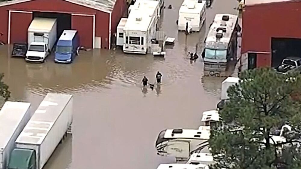 Residents navigate floodwaters after heavy flooding in the Dallas metro area submerged roads and entire neighborhoods, in Seagoville, Texas, U. S. , August 22, 2022, in this still image taken from video.  WFAA TV via ABC via REUTERS.  ATTENTION EDITORS - THIS IMAGE HAS BEEN SUPPLIED BY A THIRD PARTY MANDATORY CREDIT