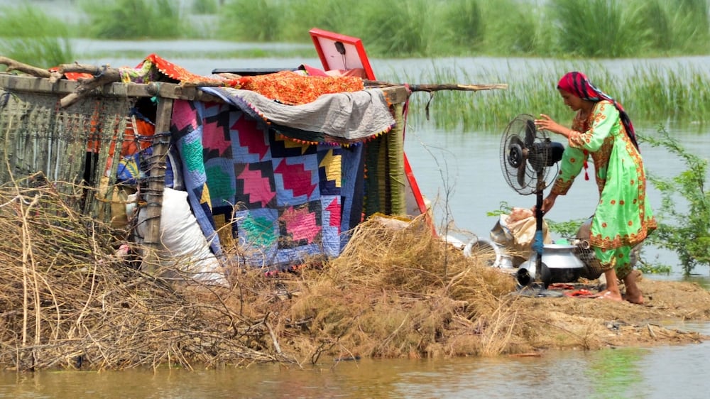 A woman taking refuge is seen with her belongings, following rains and floods during the monsoon season in Sohbatpur, Pakistan August 29, 2022.  REUTERS/Amer Hussain NO RESALES.  NO ARCHIVES. 