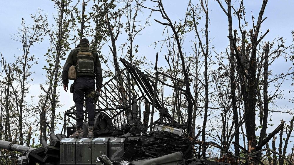 This photograph taken on September 11, 2022, shows a Ukranian soldier standing atop an abandoned Russian tank near a village on the outskirts of Izyum, Kharkiv Region, eastern Ukraine, amid the Russian invasion of Ukraine.  - Ukraine forces said that their lightning counter-offensive took back more ground in the past 24 hours, as Russia replied with strikes on some of the recaptured ground.  The territorial shifts were one of Russia's biggest reversals since its forces were turned back from Kyiv in the earliest days of the nearly seven months of fighting, yet Moscow signalled it was no closer to agreeing a negotiated peace.  (Photo by Juan BARRETO  /  AFP)