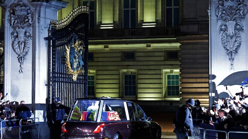 LONDON, ENGLAND - SEPTEMBER 14: The hearse carrying the flag-draped casket of Queen Elizabeth II enters the center gate at Buckingham Palace on September 14, 2022 in London, England. Queen Elizabeth II's coffin is taken in procession on a Gun Carriage of The King's Troop Royal Horse Artillery from Buckingham Palace to Westminster Hall where she will lay in state until the early morning of her funeral. Queen Elizabeth II died at Balmoral Castle in Scotland on September 8, 2022, and is succeeded by her eldest son, King Charles III.  (Photo by Chip Somodevilla / Getty Images)