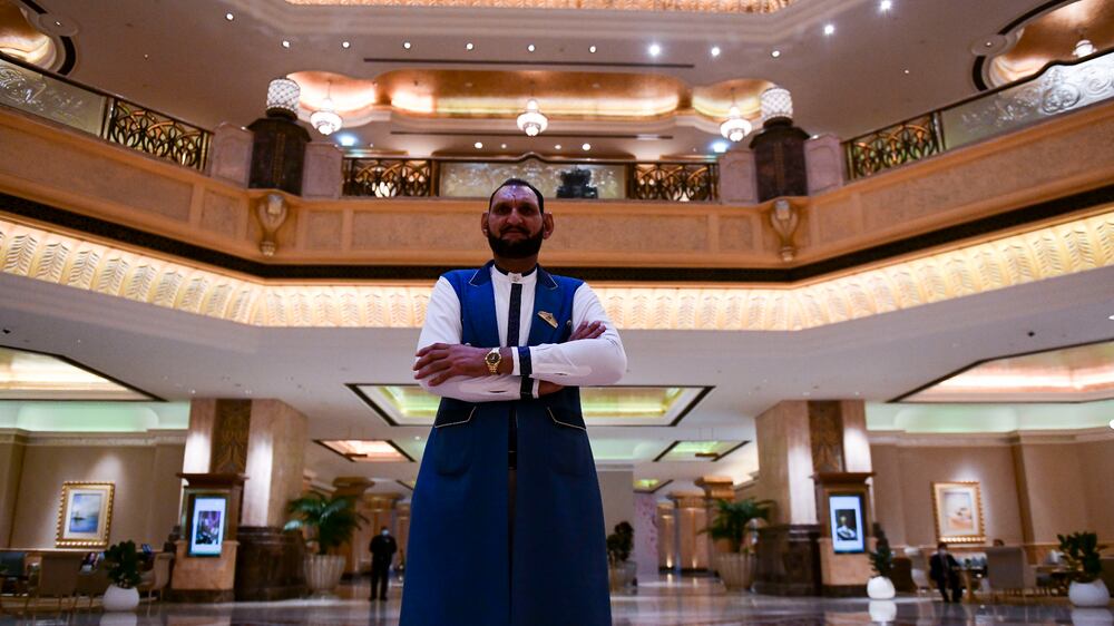 Abdul Jabbar Fazal, 50, seven feet five inches from Lahore, Pakistan works as a  doorman at Emirates Place in Abu Dhabi. Khushnum Bhandari / The National
