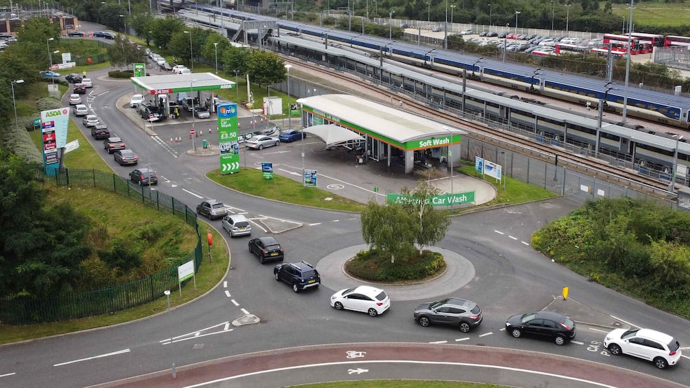 An aerial view shows customers queueing in their cars to access an Asda petrol station in east London on September 25, 2021.  - The UK government is poised to temporarily ease visa rules to attract more foreign lorry drivers, reports said Saturday, as it grapples with a growing shortage that has now hit fuel supplies.  (Photo by Daniel LEAL-OLIVAS  /  AFP)