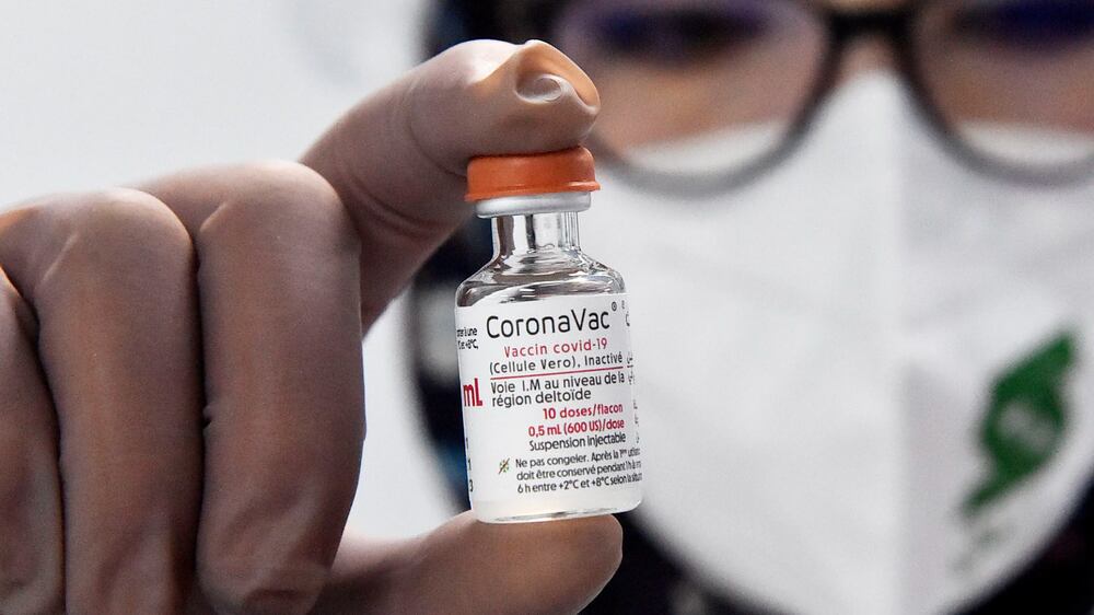 A person shows a dose of the CoronaVac COVID-19 vaccine at the Saidal factory in Constantine, Wednesday, Sept. 29, 2021.  Algeria's first home-produced coronavirus vaccines came off the assembly line Wednesday, as part of a cooperation deal with the makers of China's Sinovac vaccine.  The "CoronaVac" vaccines were made at the Saidal factory in the Algerian city of Constantine, which authorities say is aiming to produce up to 5 million doses per month.  (AP Photo)