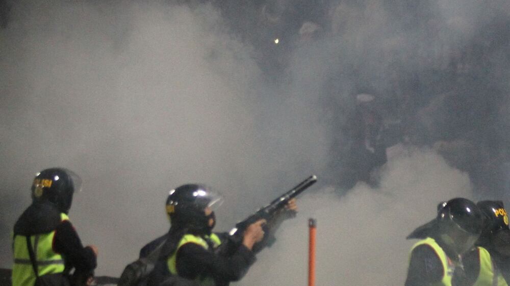 A riot police officer fires tear gas during a riot after the league BRI Liga 1 football match between Arema vs Persebaya at Kanjuruhan Stadium in Malang, East Java province, Indonesia, October 2, 2022, in this photo taken by Antara Foto.  Antara Foto/Ari Bowo Sucipto/via REUTERS  ATTENTION EDITORS - THIS IMAGE HAS BEEN SUPPLIED BY A THIRD PARTY.  MANDATORY CREDIT.  INDONESIA OUT.  NO COMMERCIAL OR EDITORIAL SALES IN INDONESIA. 