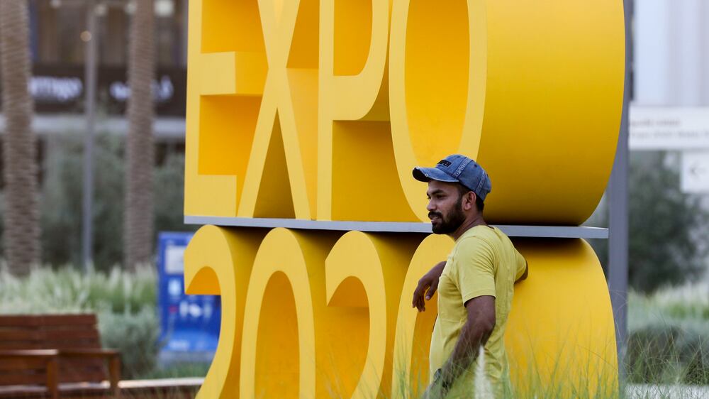 Visitor poses near the Expo 2020 signage on the grounds of Dubai Expo. Khushnum Bhandari/ The National
