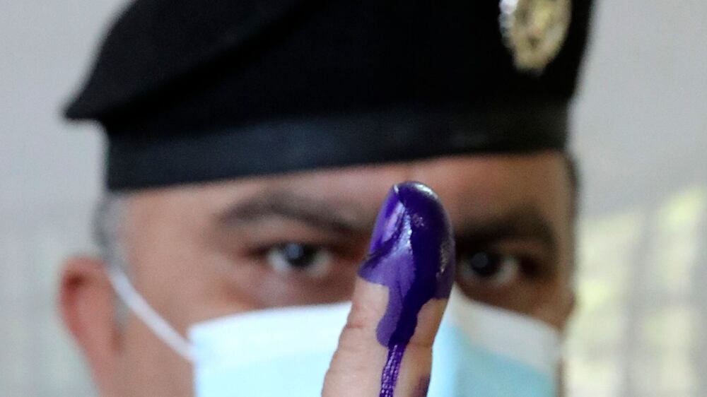 A members of Iraq's security forces shows his ink-stained finger as he takes part in early voting for the parliamentary elections in Baghdad, on October 8, 2021.  - More than 25 million Iraqis are eligible to vote for a new parliament on October 10, in the fifth such vote since a US-led invasion toppled dictator Saddam Hussein in 2003.  A total of 329 seats are up for grabs in the election, which was moved forward from 2022 as a concession to youth-led pro-democracy protests that erupted in late 2019.  (Photo by Sabah ARAR  /  AFP)