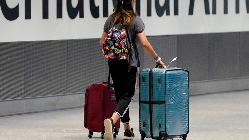 FILE - In this Monday, Aug.  2, 2021 file photo, a passenger arrives from a flight at Terminal 5 of Heathrow Airport in London.  The British government said Thursday Oct.  7, 2021, that it is to relax travel rules further next week, a move that will open up many long-distance holiday destinations to travelers for the first time since the onset of the coronavirus pandemic a year and half ago.  (AP Photo / Matt Dunham, File)