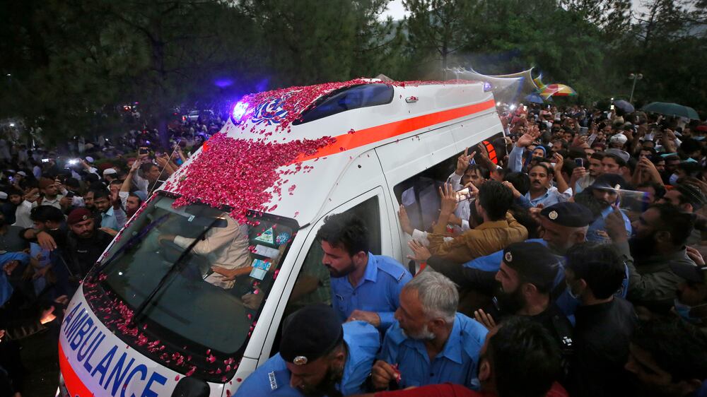 Police officers clear the way for an ambulance carrying the casket of Pakistani nuclear scientist Abdul Qadeer Khan following his funeral prayer, in Islamabad, Pakistan, Sunday, Oct.  10, 2021.  Khan, a controversial figure known as the father of Pakistan's nuclear bomb, died Sunday of COVID-19 following a lengthy illness, his family said.  He was 85.  (AP Photo / Anjum Naveed)