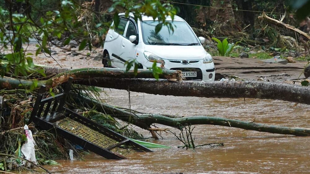 A car stucked in mud waters is pictured after flash floods caused by heavy rains at Thodupuzha in India's Kerala state on October 16, 2021.  (Photo by Appu S.  Narayanan  /  AFP)