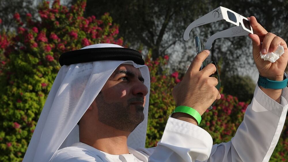 An Emirati uses a wearing special glasses to watch a partial solar eclipse at Al Thuraya Astronomy Center in Gulf emirate of Dubai, United Arab Emirates on 25 October 2022.   EPA / ALI HAIDER