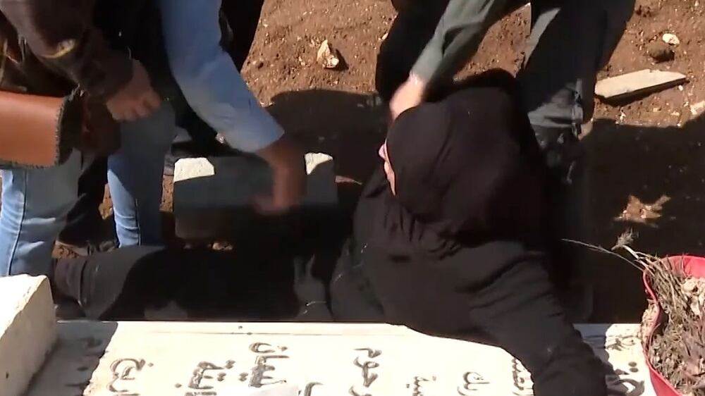Palestinian mother refuses to leave son's grave as Israel bulldozes cemetery