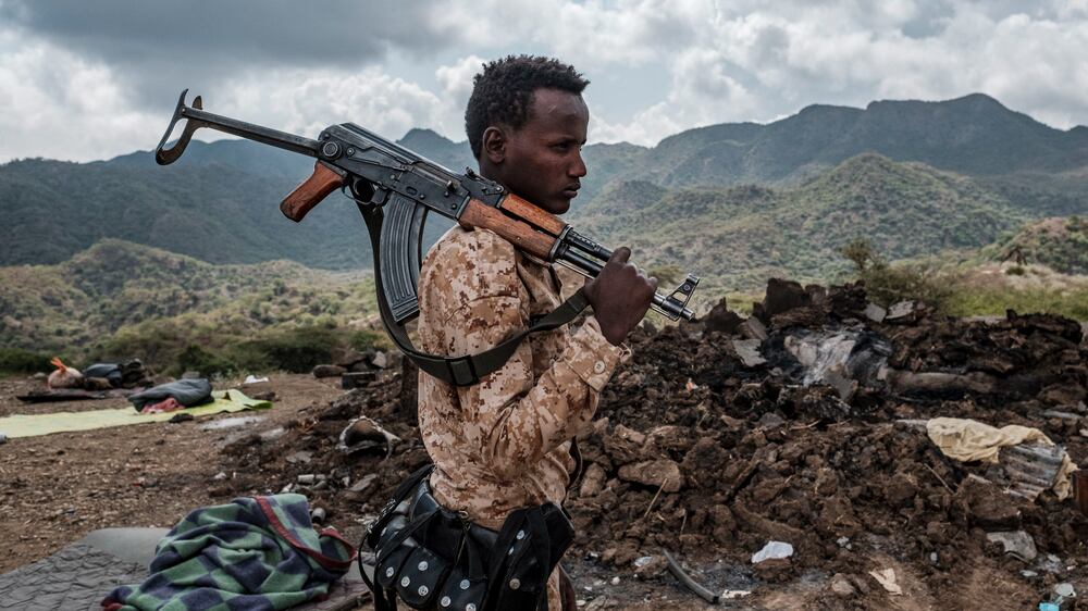 A member of the Afar Special Forces stands in front of the debris of a house in the outskirts of the village of Bisober, Tigray Region, Ethiopia, on December 09, 2020.Several houses in the village were damaged during the confrontations between the Tigray Forces and the Ethiopian Defense Forces. (Photo by EDUARDO SOTERAS / AFP)