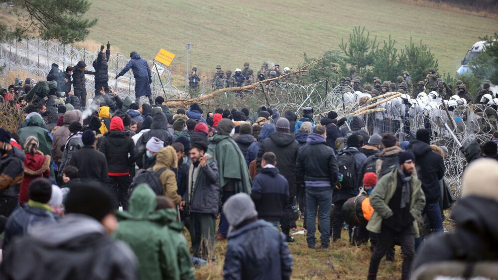 Migrants from the Middle East and elsewhere gather at the Belarus-Poland border near Grodno, Belarus, Monday, Nov.  8, 2021.  Poland increased security at its border with Belarus, on the European Union's eastern border, after a large group of migrants in Belarus appeared to be congregating at a crossing point, officials said Monday.  The development appeared to signal an escalation of a crisis that has being going on for months in which the autocratic regime of Belarus has encouraged migrants from the Middle East and elsewhere to illegally enter the European Union, at first through Lithuania and Latvia and now primarily through Poland.  (Leonid Shcheglov / BelTA via AP)