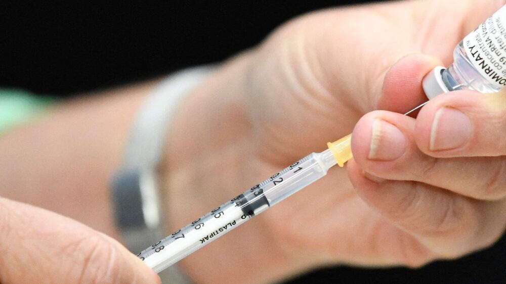 A member of the medical team fills a syringe with the vaccine of BioNtech/Pfizer in a Covid-19 vaccination station in Stuttgart, southern Germany, on November 9, 2021, amid the ongoing coronavirus pandemic.  (Photo by THOMAS KIENZLE  /  AFP)