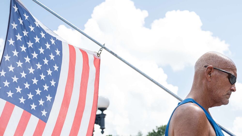 FRANKFORT, KY - AUGUST 28: A man with a US flag, and a.  Make America Great Again hat stands during a rendition of the US National Anthem during the Kentucky Freedom Rally at the capitol building on August 28, 2021 in Frankfort, Kentucky.  Demonstrators gathered on the grounds of the capitol to speak out against a litany of issues, including Kentucky Gov.  Andy Beshears management of the coronavirus pandemic, abortion laws, and the teaching of critical race theory.  Demonstrators and speakers also refuted the legitimacy of the 2020 United State presidential election, claiming that former President Donald Trump won and should be reinstated.    Jon Cherry / Getty Images / AFP
