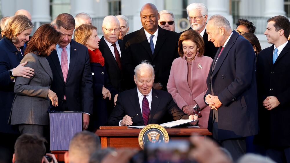U. S.  President Joe Biden celebrates with lawmakers including ���Vice President Kamala Harris���, House Speaker Nancy Pelosi (D-CA) and Senate Majority Leader Chuck Schumer (D-NY) before signing the Infrastructure Investment and Jobs Act on the South Lawn at the White House in Washington, U. S.  November 15, 2021.   REUTERS / Jonathan Ernst