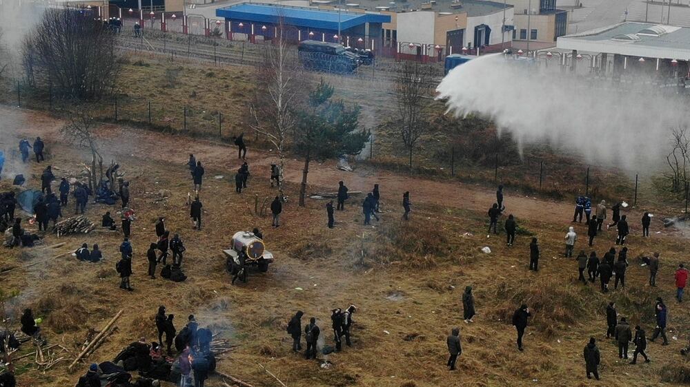 Polish law enforcement officers use a water cannon on migrants, who attempt to cross the Belarusian-Polish border at Bruzgi - Kuznica checkpoint in the Grodno region, Belarus November 16, 2021.  Picture taken with a drone.  Leonid Scheglov/BelTA/Handout via REUTERS  ATTENTION EDITORS - THIS IMAGE HAS BEEN SUPPLIED BY A THIRD PARTY.  NO RESALES.  NO ARCHIVES.  MANDATORY CREDIT. 