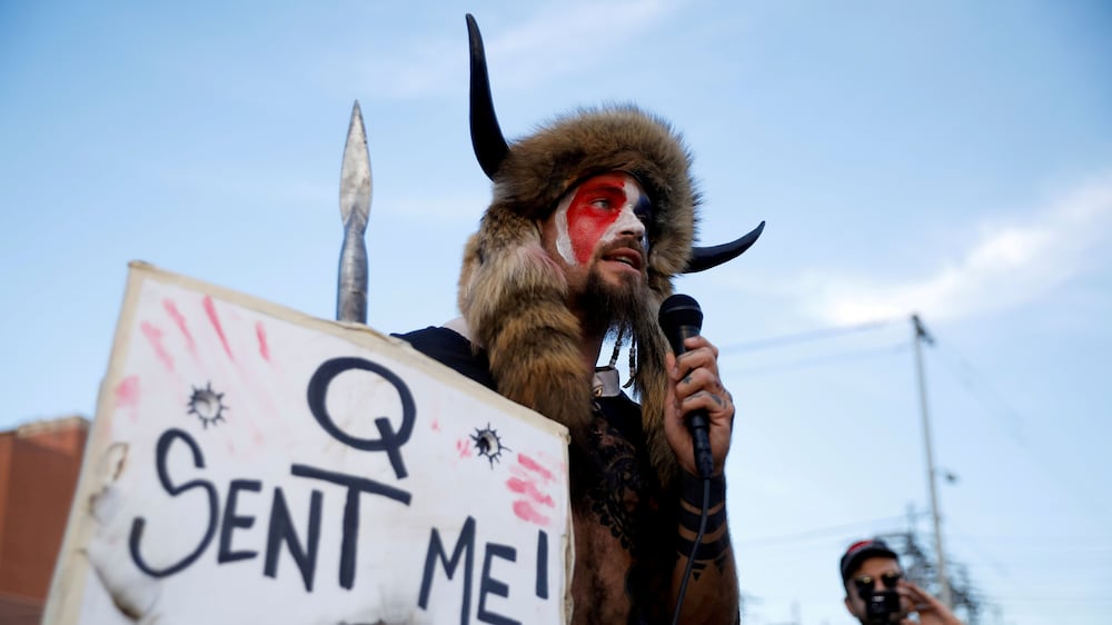 FILE PHOTO: Jacob Chansley, holding a sign referencing QAnon, speaks as supporters of U. S.  President Donald Trump gather to protest about the early results of the 2020 presidential election, in front of the Maricopa County Tabulation and Election Center (MCTEC), in Phoenix, Arizona November 5, 2020.  REUTERS / Cheney Orr / File Photo
