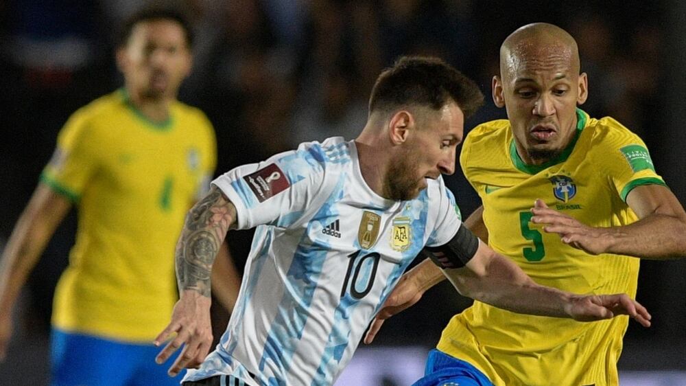 Argentina's Lionel Messi (C) is challenged by Brazil's Edenilson during their South American qualification football match for the FIFA World Cup Qatar 2022 at the San Juan del Bicentenario stadium in San Juan, Argentina, on November 16, 2021.  (Photo by Juan Mabromata  /  AFP)