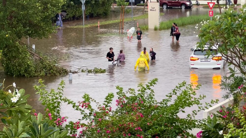 UAE residents wade across flooded streets after heavy rain
