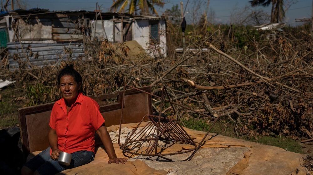 FILE - Mari Carmen Zambrano poses for a photo on her broken and wet bed as she dries it outside her home that lost its roof to Hurricane Ian in La Coloma, in the province of Pinar del Rio, Cuba, Wednesday, Oct.  5, 2022.  (AP Photo / Ramon Espinosa, File)