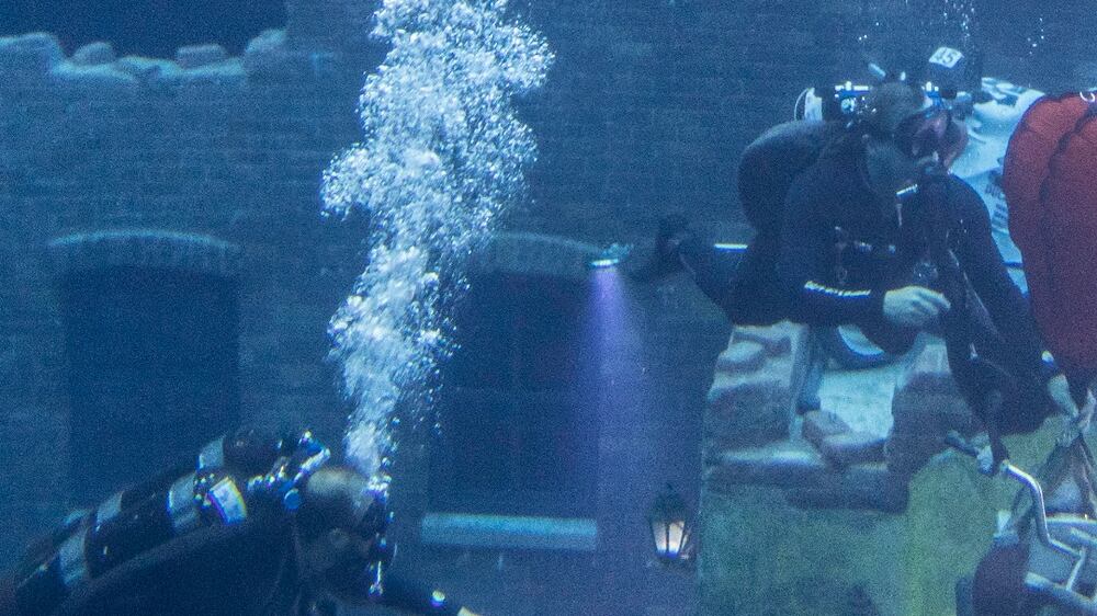 Deep Dive Dubai demonstrating how they move heavy objects in and out of the pool. 
Divers Richard Lundgren and Omar Farooq move one of the display motorcycles.
Antonie Robertson/The National
