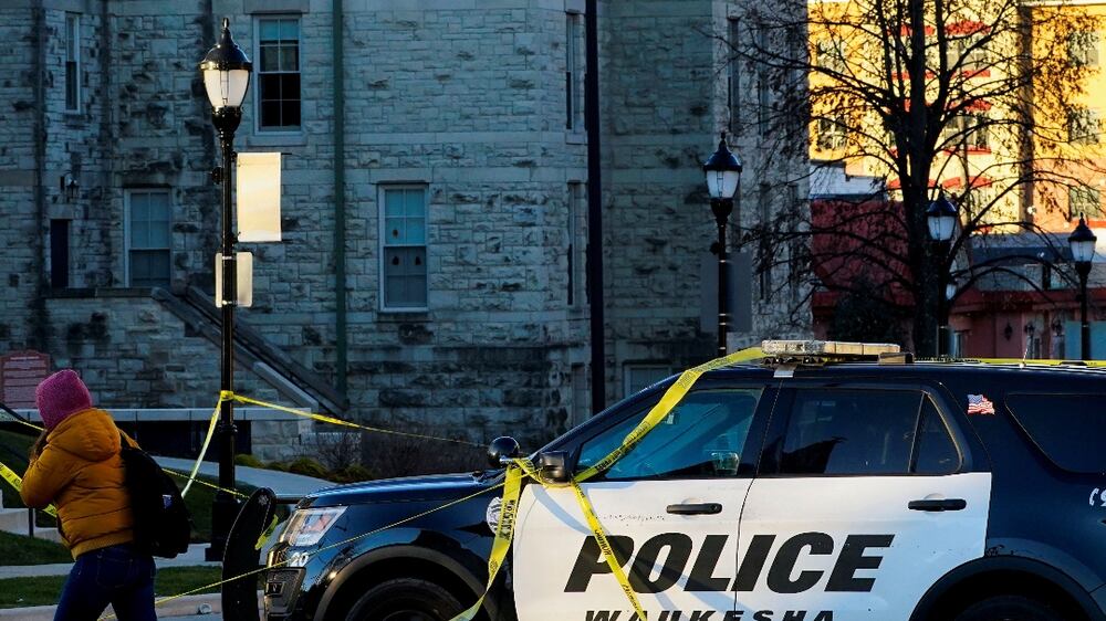 A person walks past a police car blocking Main Street the morning after a car ploughed through a holiday parade in Waukesha, Wisconsin, U. S. , November 22, 2021.   REUTERS / Cheney Orr     TPX IMAGES OF THE DAY