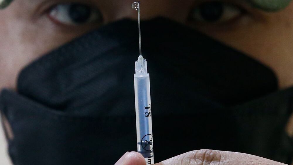 A police officer in the Medical Reserve Force prepares a dose of the AstraZeneca (Vaxzevria) COVID-19 vaccine booster shot at a village center as part of a nationwide three-day inoculation drive targeting some nine million citizens, in Quezon City, Metro Manila, Philippines 29 November 2021.  A health expert from the Philippine Genome Center has urged the public to get vaccinated for more protection during the pandemic, as concerns are growing following discovery of the new COVID-19 Omicron variant.   EPA / ROLEX DELA PENA