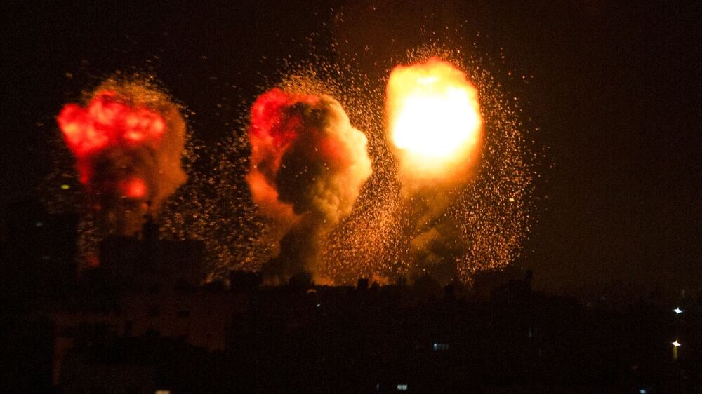 A ball of fire and a plume of smoke rise above buildings in south of City Strip as Israeli warplanes target the Palestinian enclave, early on, on December 4, 2022.  (Photo by AFP)