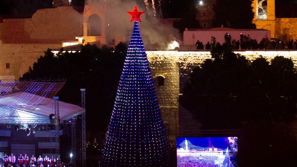 Fireworks burst over the Church of the Nativity in Manger Square in the West Bank town of Bethlehem during the lighting of the Christmas tree, Saturday, Dec.  4, 2021.  It was the fist time since the coronavirus that the square was full for the lighting of the Christmas tree, but local vendors were hoping for a return of tourism.  (AP Photo / Maya Alleruzzo)