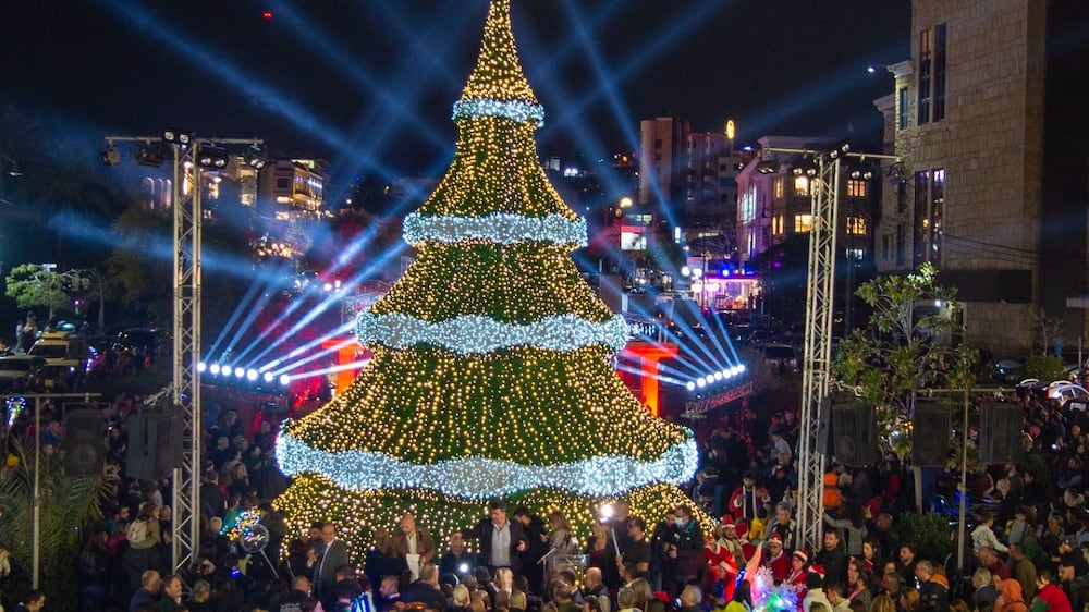 People gather around a giant Christmas tree, which has been officially lit up at the entrance of Byblos (Jbeil), Lebanon, 08 December 2022.   EPA / WAEL HAMZEH