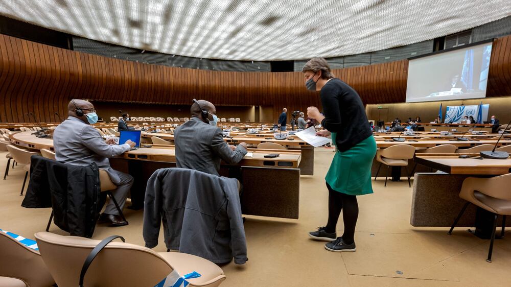 A UN staff (R) speaks with delegates from Burundi during an extraordinary meeting on Ethiopia held mainly remotely at the United Nations (UN) Human Rights Council in Geneva on December 17, 2021.  - The United Nations warned that all sides in Ethiopia's 13-month conflict were committing severe abuses, and cautioned that generalised violence could ensue, with implications for the entire region.  (Photo by Fabrice COFFRINI  /  AFP)