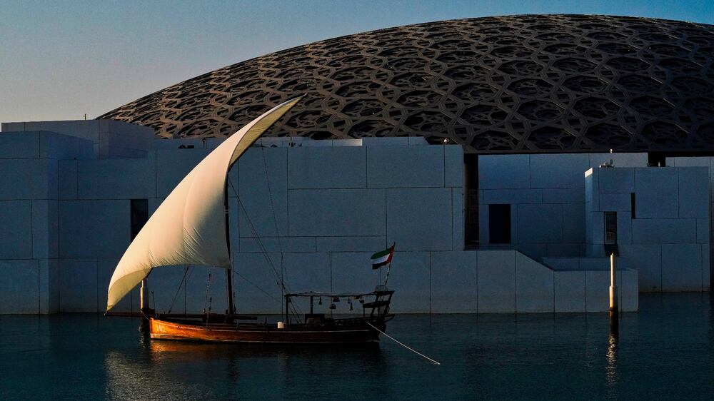 A sail boat is anchored at sunset outside of the Louvre Abu Dhabi in Abu Dhabi, United Arab Emirates, Thursday, Dec.  16, 2021.  (AP Photo / Jon Gambrell)