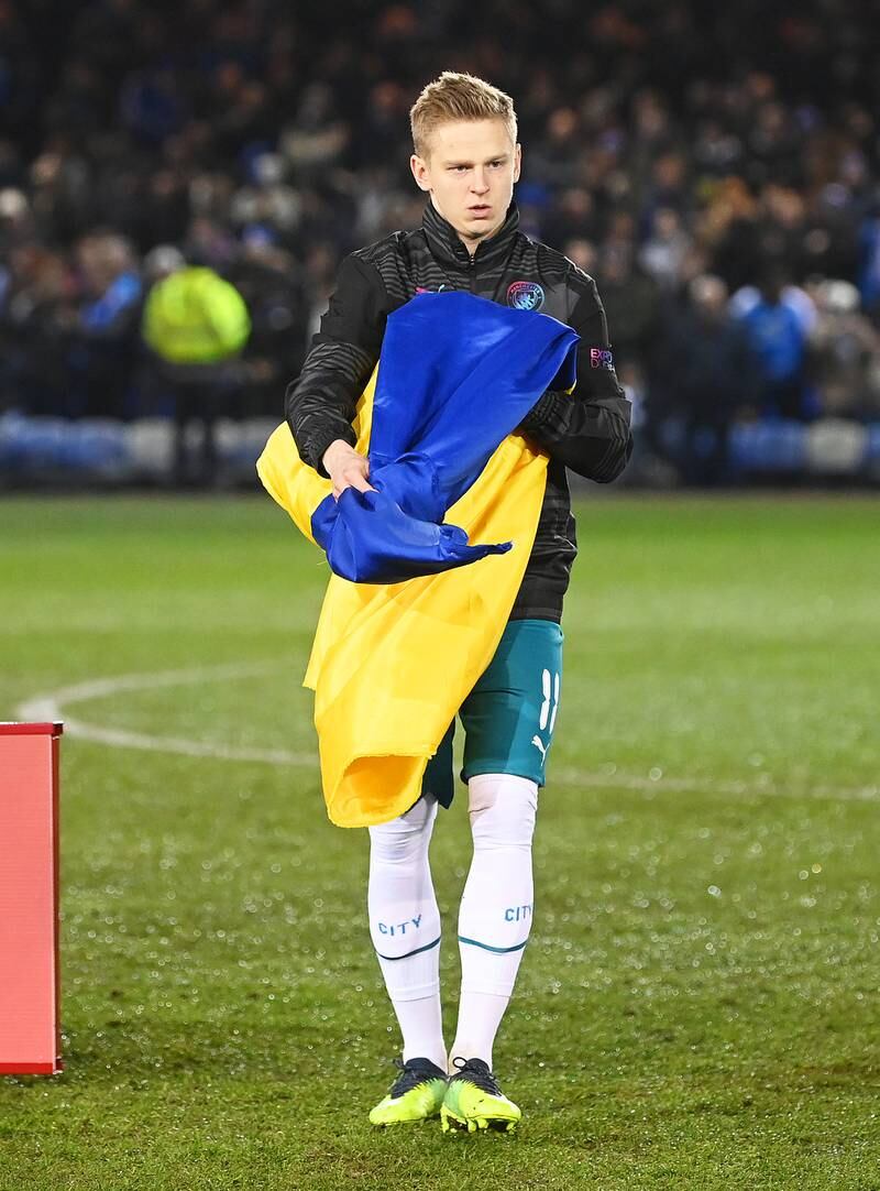 Oleksandr Zinchenko of Manchester City holds a Ukrainian flag. Getty