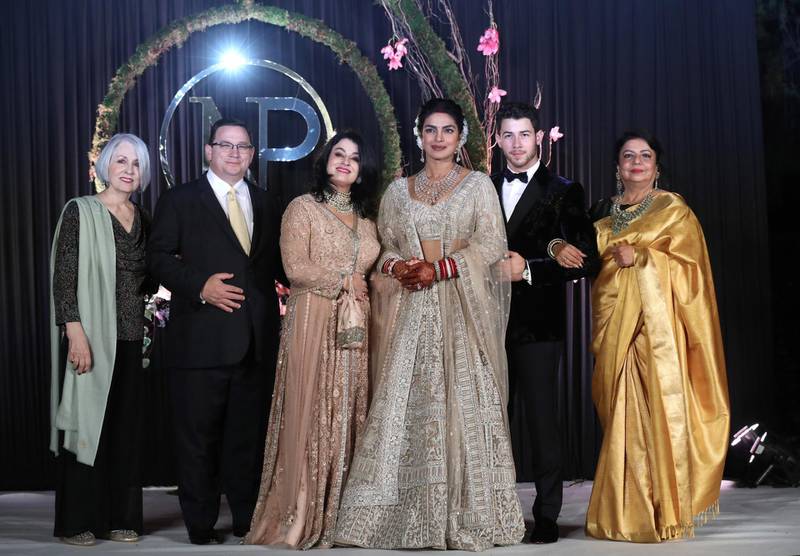 Priyanka Chopra (3-R) and US musician Nick Jonas (2-R) pose for photographs with family members, the bride's mother Madhu Chopra (R), the groom's father Paul Kevin Jonas Sr. (2-L), mother Denise Miller Jonas (3-L) and grandmother Frances Madonia-Miller (L) during a reception in New Delhi, India, 04 December 2018.
