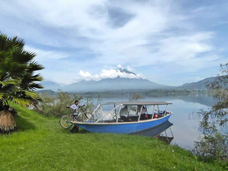 A cyclist loads his bike onto a boat to be taken across Lake Ruhondo in Rwanda, in the foothills of the Volcanoes National Park, home to mountain gorillas. Will Hide